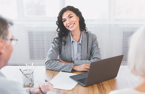 Mature couple consulting with financial adviser at office