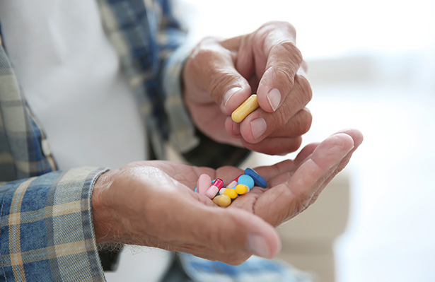 Senior man taking pills closeup