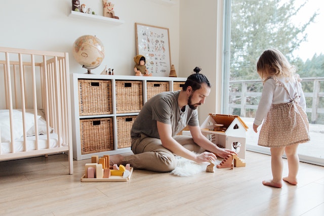 father playing with child on floor