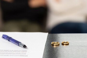 prenup and wedding rings on table