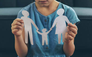 child holding paper cutout of family