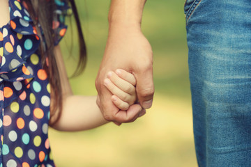 child holding hands with parent