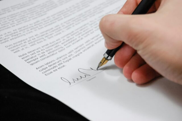 person signing paper